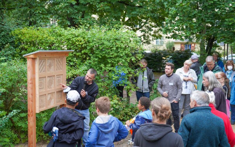 Markus Schmidt erklärt Besucherinnen und Besuchern die neue Wildbienennisthilfe im PikoPark in Berlin.